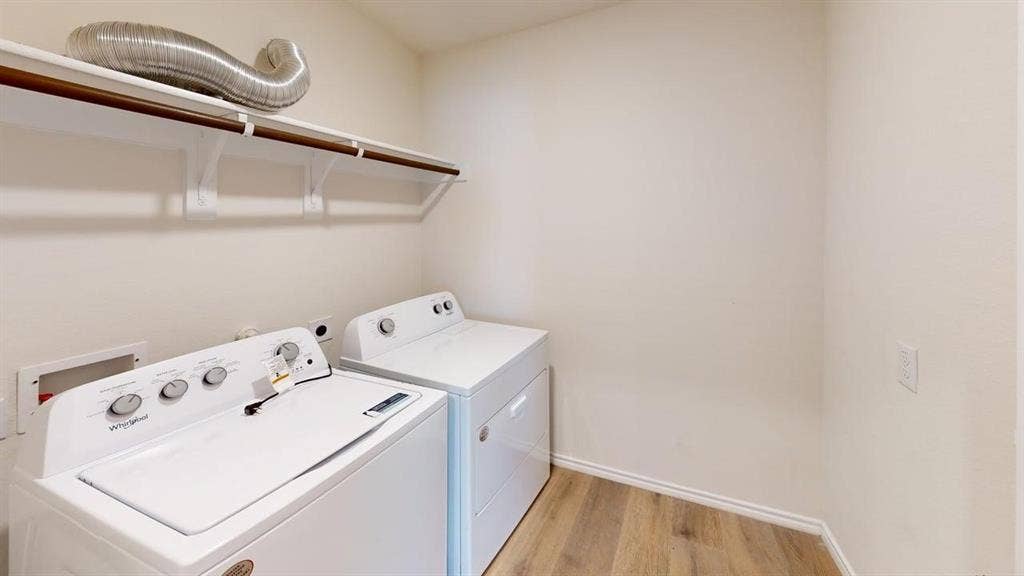 6534 Whitecap Drive, Princeton, TX 75407 Laundry area featuring wood-finish flooring, white walls, and a built-in shelf with a hanging rod