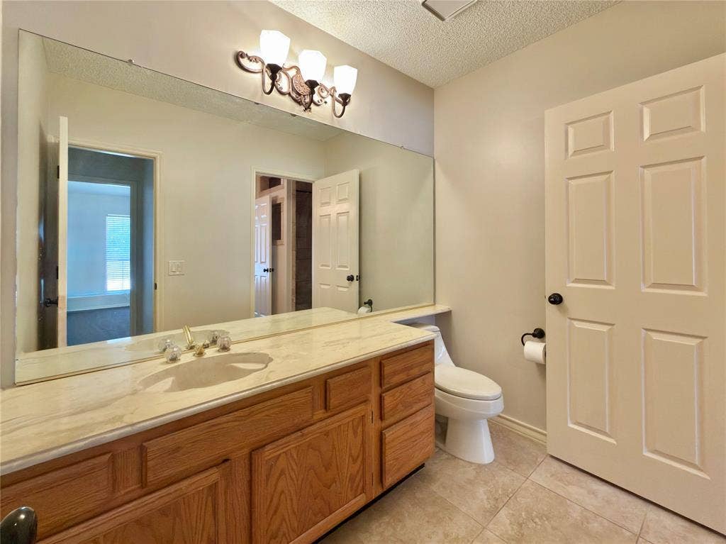 418 Newberry Street, Grand Prairie, TX 75052 Vanity with a single undermount sink, a light-toned countertop, and wood-finish cabinetry