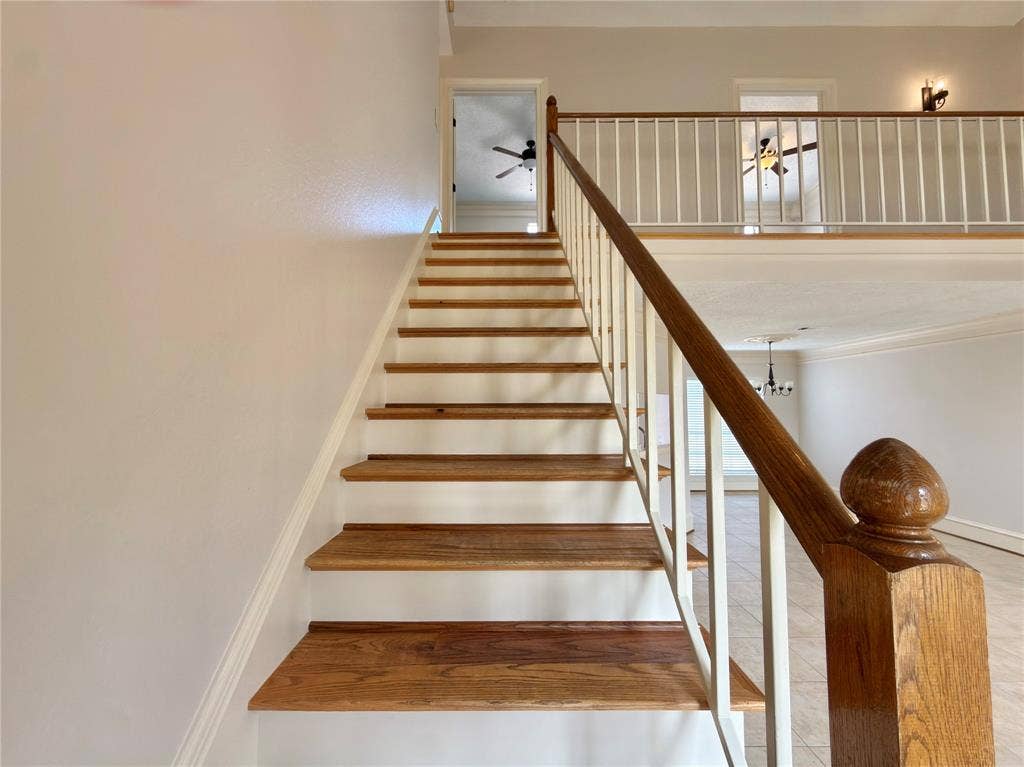 418 Newberry Street, Grand Prairie, TX 75052 Wood-finish staircase with white risers and a matching wood handrail