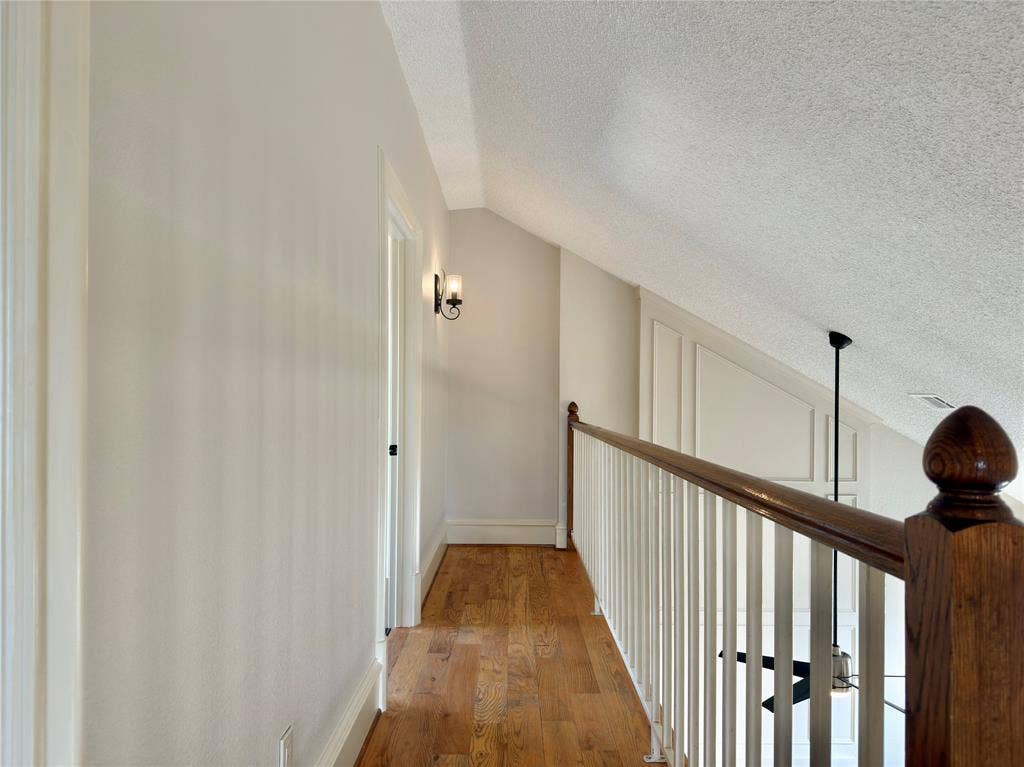 418 Newberry Street, Grand Prairie, TX 75052 Hardwood-style flooring throughout, white painted walls, and an angled ceiling