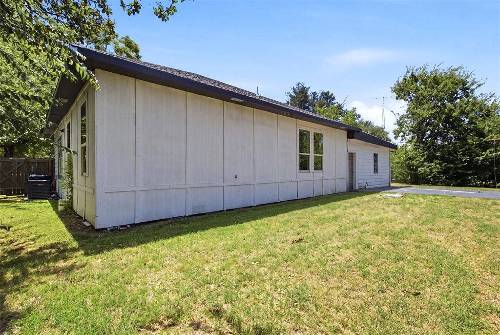 1812 Oneal Street, Greenville, TX 75401 Expansive side yard with a grass lawn, mature trees, and a paved surface