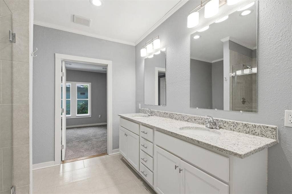 1812 Oneal Street, Greenville, TX 75401 Dual vanity with integrated sinks, granite-style countertop, and white cabinetry