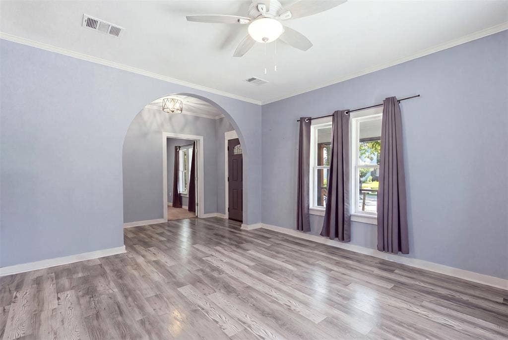 1812 Oneal Street, Greenville, TX 75401 Wood-finish flooring, arched entryway, ceiling fan with integrated lighting, recessed lighting, and white trim