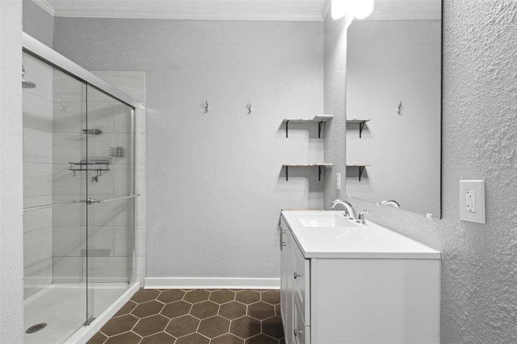 1812 Oneal Street, Greenville, TX 75401 White vanity with integrated sink, chrome faucet, and expansive wall mirror