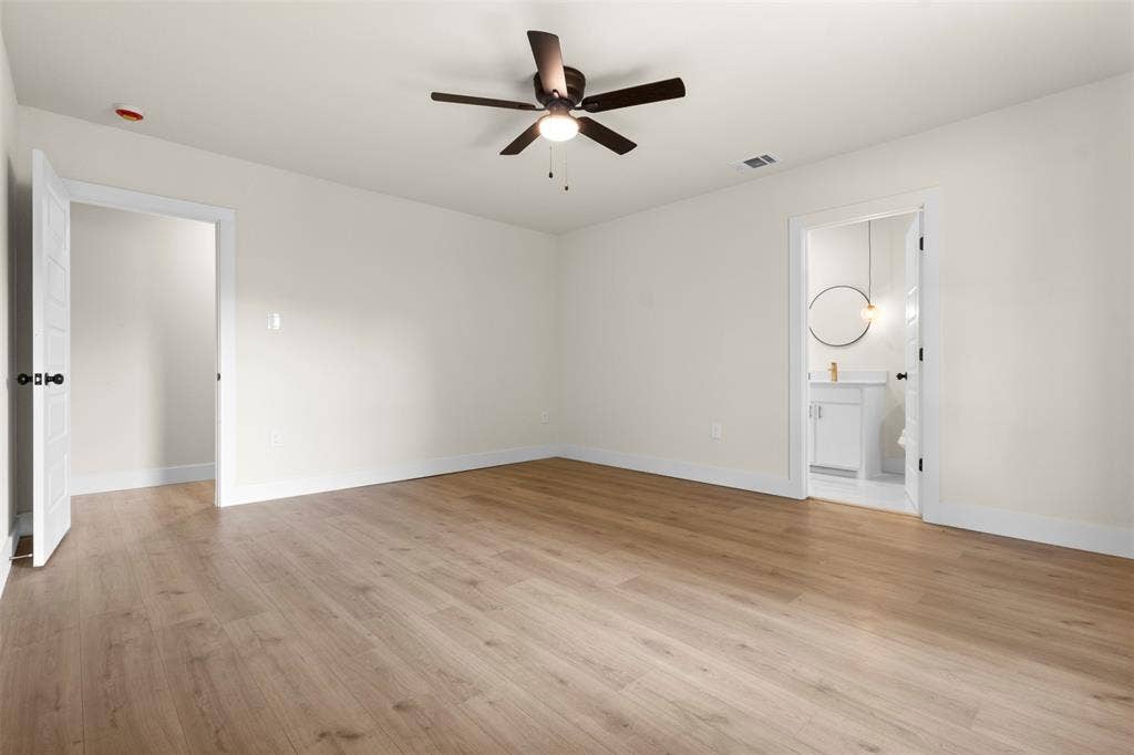 212 E Marguerita Drive, Garland, TX 75040 Spacious room featuring wood-finish flooring, light-colored walls, and a ceiling fan with integrated lighting