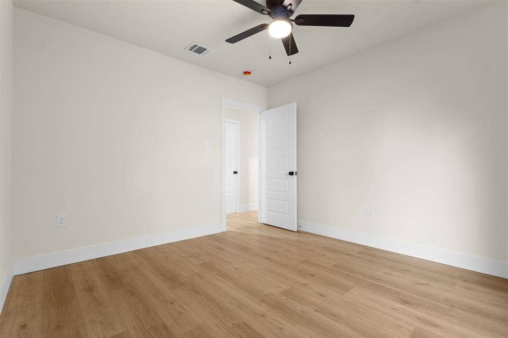 212 E Marguerita Drive, Garland, TX 75040 Wood-finish flooring with white baseboards, a ceiling fan with integrated lighting, and a paneled interior door