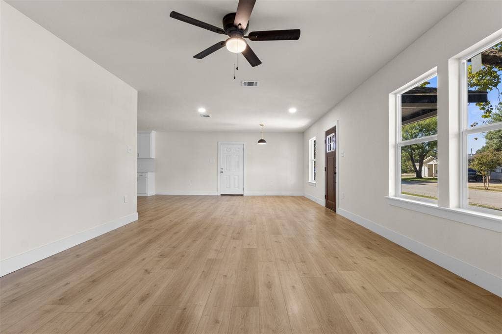 212 E Marguerita Drive, Garland, TX 75040 Wood-finish flooring throughout, bright white walls, recessed lighting, and multiple windows with white trim
