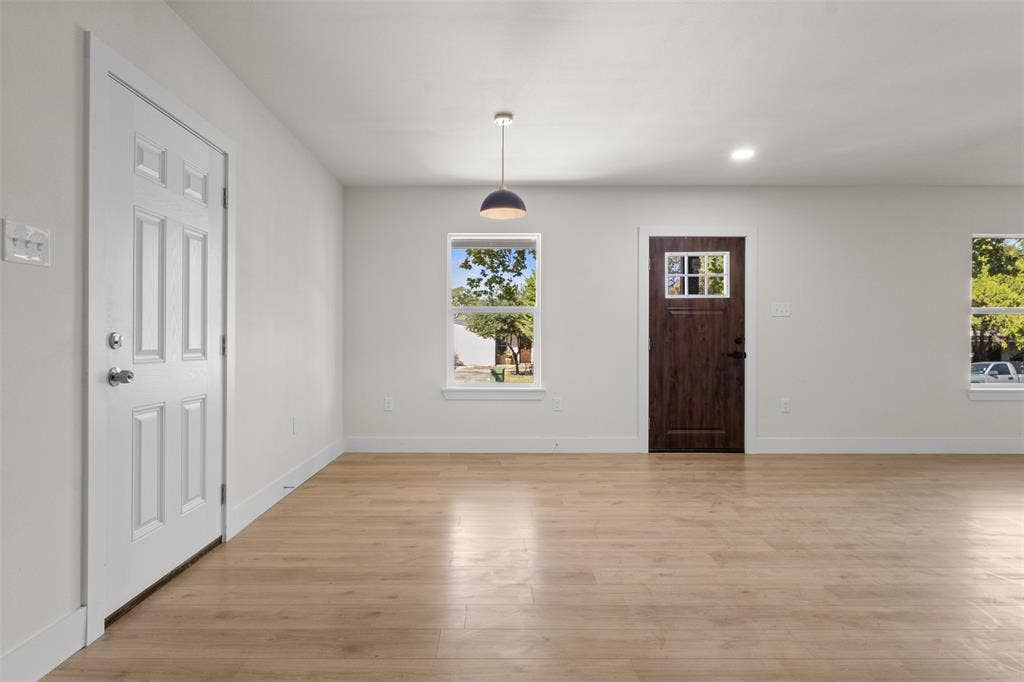 212 E Marguerita Drive, Garland, TX 75040 Wood-finish flooring, white walls, white trim, recessed lighting, and a modern pendant light