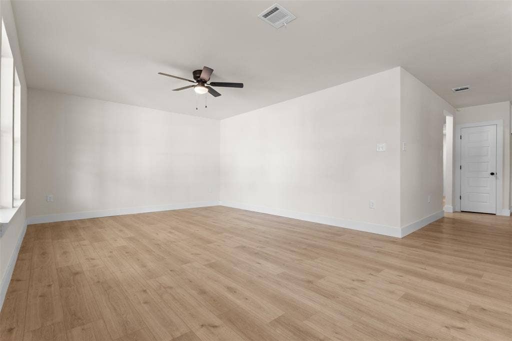 212 E Marguerita Drive, Garland, TX 75040 Spacious room featuring wood-finish flooring, white walls, and a ceiling fan