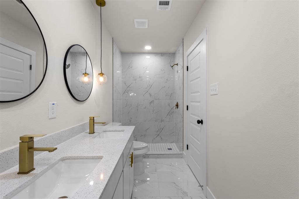212 E Marguerita Drive, Garland, TX 75040 Dual vanity with gold-tone fixtures and integrated sinks