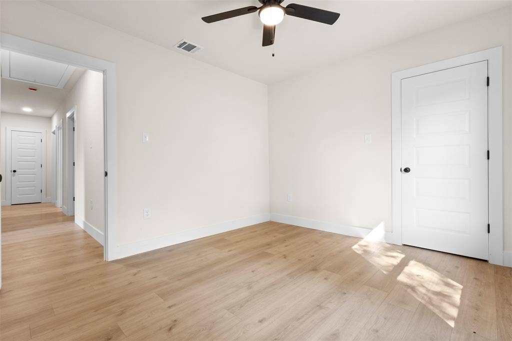212 E Marguerita Drive, Garland, TX 75040 Light wood-finish flooring, white walls, modern five-panel interior doors, and a ceiling fan with integrated lighting