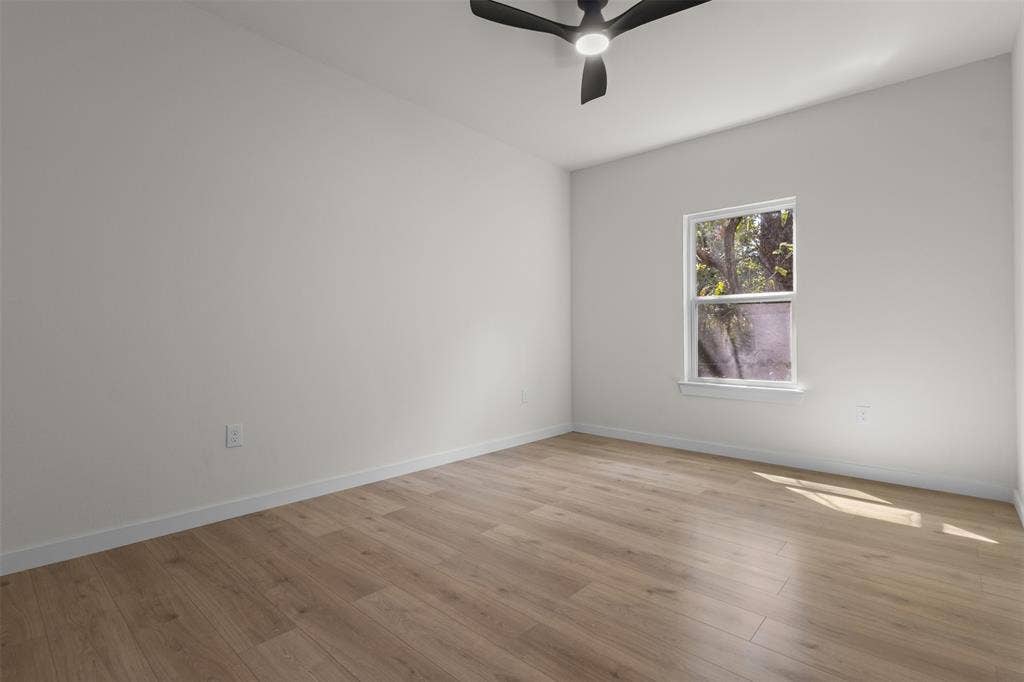 333 Levant Avenue, Dallas, TX 75217 Neutral wall color, wood-finish flooring, single window, white trim, and a ceiling fan