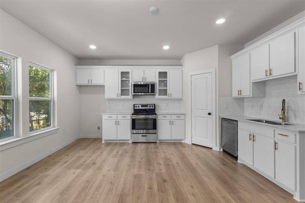 333 Levant Avenue, Dallas, TX 75217 Spacious kitchen with wood-finish flooring, white cabinetry, stainless steel appliances, and recessed lighting