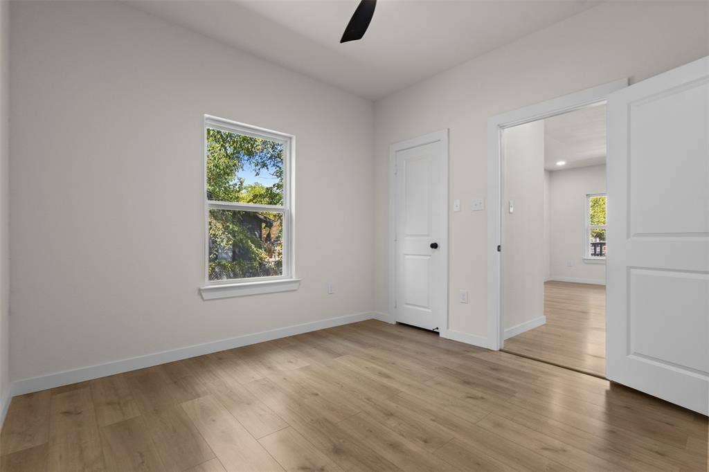 333 Levant Avenue, Dallas, TX 75217 Light wood-finish flooring throughout, white walls, and a window with white trim