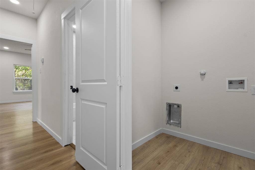 333 Levant Avenue, Dallas, TX 75217 Dedicated laundry area with hookups, wood-finish flooring, and crisp white walls