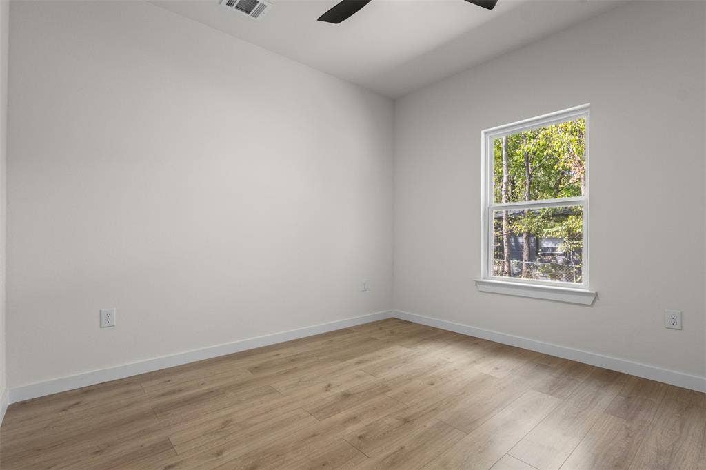 333 Levant Avenue, Dallas, TX 75217 Wood-finish flooring, white walls, and a single window with white trim