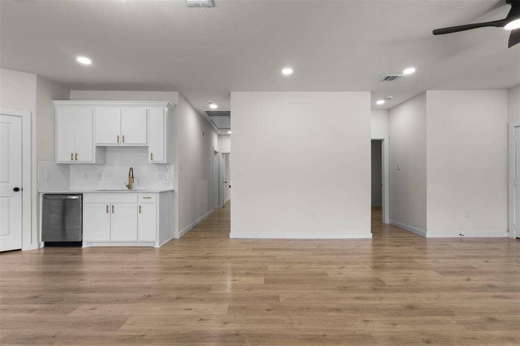 333 Levant Avenue, Dallas, TX 75217 Wood-finish flooring, recessed lighting, ceiling fan, white cabinetry with gold-tone hardware, and a stainless steel dishwasher