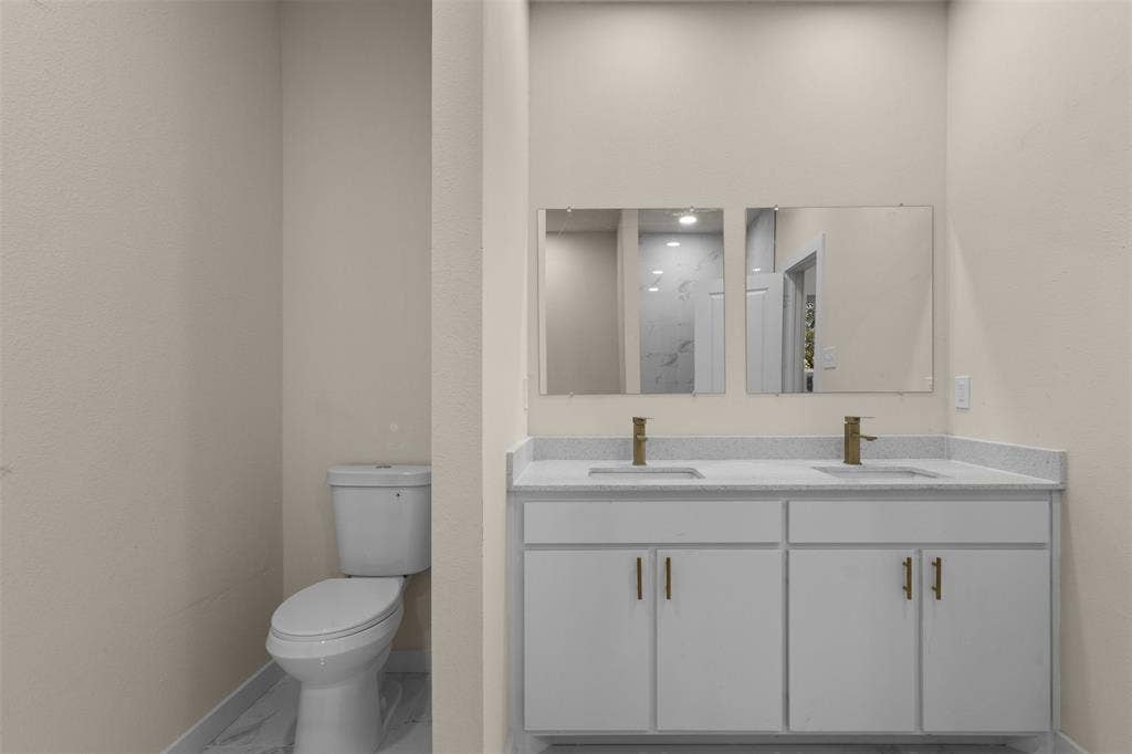 333 Levant Avenue, Dallas, TX 75217 Dual vanity with light-toned countertop and gold-finish faucets