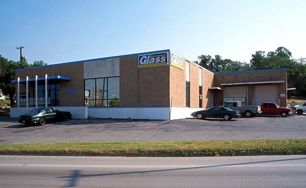 4222 Harry Hines Boulevard, Dallas, TX 75219 Brick exterior building with expansive front windows, a blue awning, and multiple overhead doors