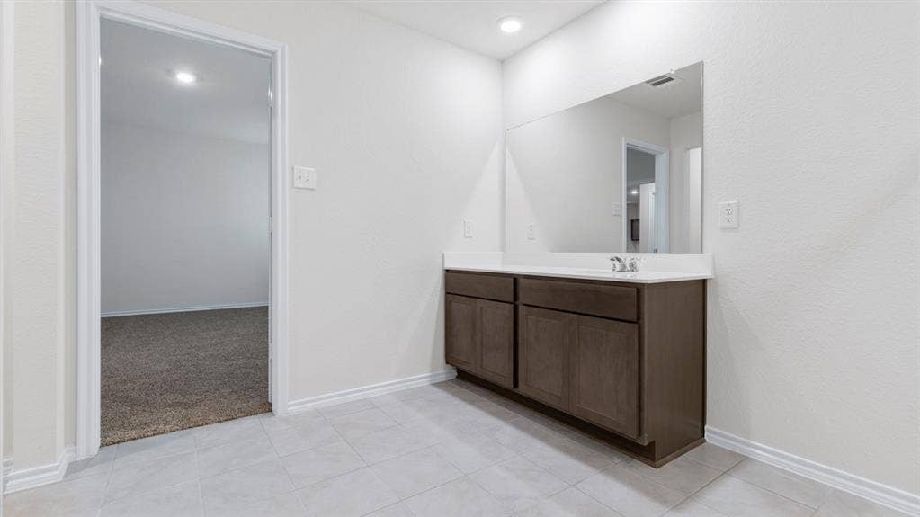 205 Brooks Street, Bullard, TX 75757 White vanity countertop with an integrated sink, framed by a large wall-mounted mirror