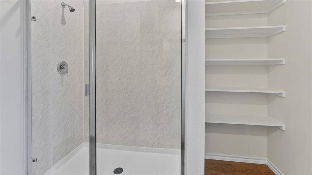 201 Brooks Street, Bullard, TX 75757 Glass-enclosed shower with a chrome showerhead and control