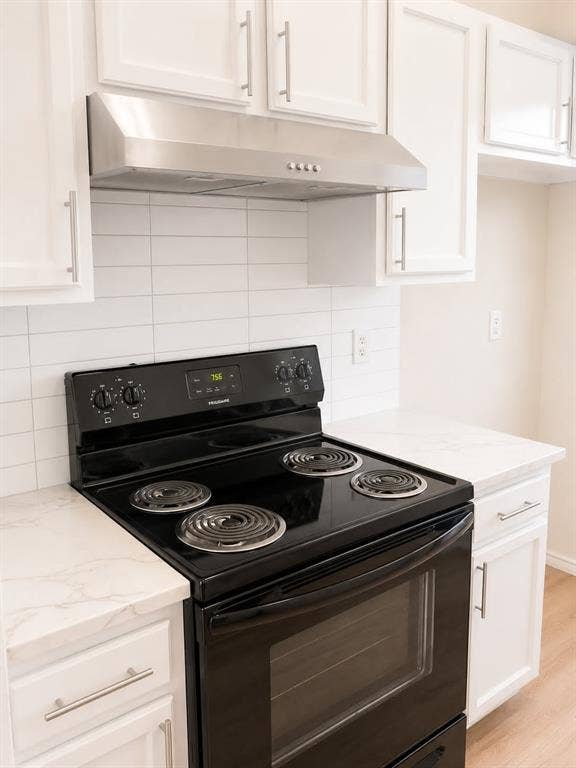 4952 Berridge Lane, Dallas, TX 75227 White cabinetry with brushed nickel hardware, stainless steel range hood, white subway tile backsplash, black electric range, and white countertops