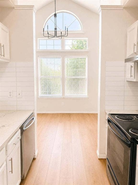 4952 Berridge Lane, Dallas, TX 75227 Vaulted ceiling with an arched window and modern chandelier, wood-finish flooring, white cabinetry with stainless hardware, integrated dishwasher, and white subway tile backsplash