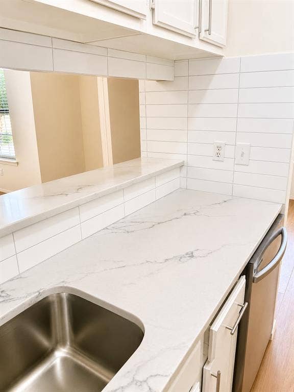 4952 Berridge Lane, Dallas, TX 75227 Kitchen featuring white upper cabinetry, stainless steel sink, white countertops, and a white subway tile backsplash