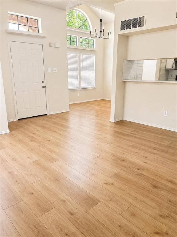 4952 Berridge Lane, Dallas, TX 75227 Vaulted ceilings with an arched window, wood-finish flooring, and a modern chandelier