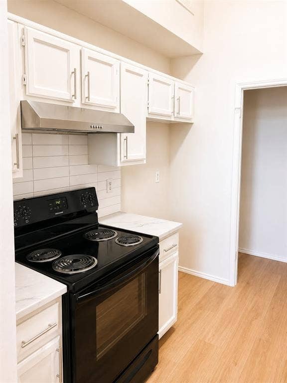 4952 Berridge Lane, Dallas, TX 75227 Kitchen with white shaker-style cabinetry, stainless steel range hood, white subway tile backsplash, and wood-finish flooring
