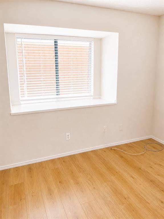 4952 Berridge Lane, Dallas, TX 75227 Light wood-finish flooring with white baseboards and a recessed window