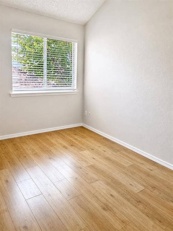 4952 Berridge Lane, Dallas, TX 75227 Wood-finish flooring, white walls, and a window with horizontal blinds