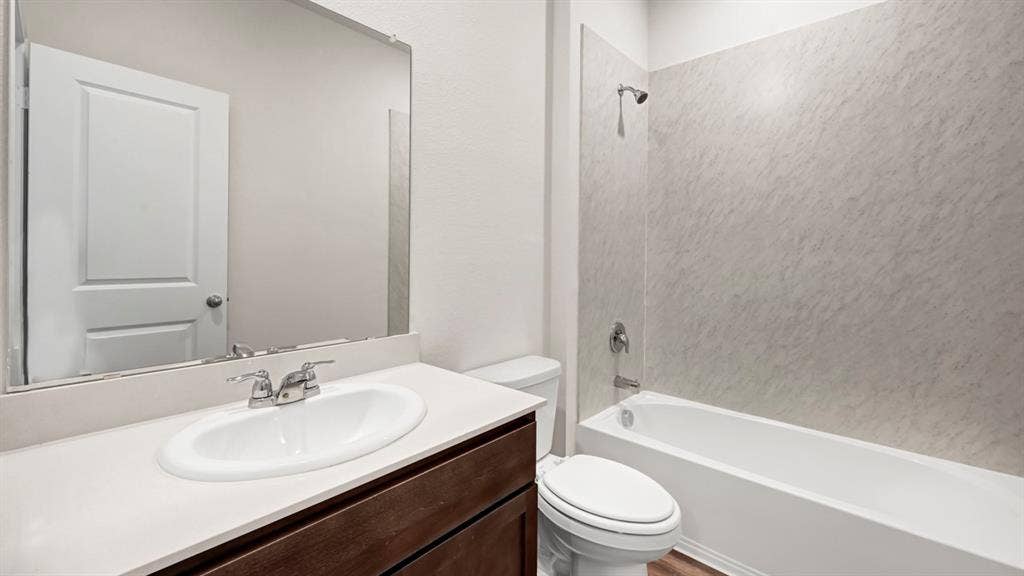 197 Brooks Street, Bullard, TX 75757 Dark wood-finish vanity with an integrated oval sink, chrome-finish faucet, and a spacious wall-mounted mirror