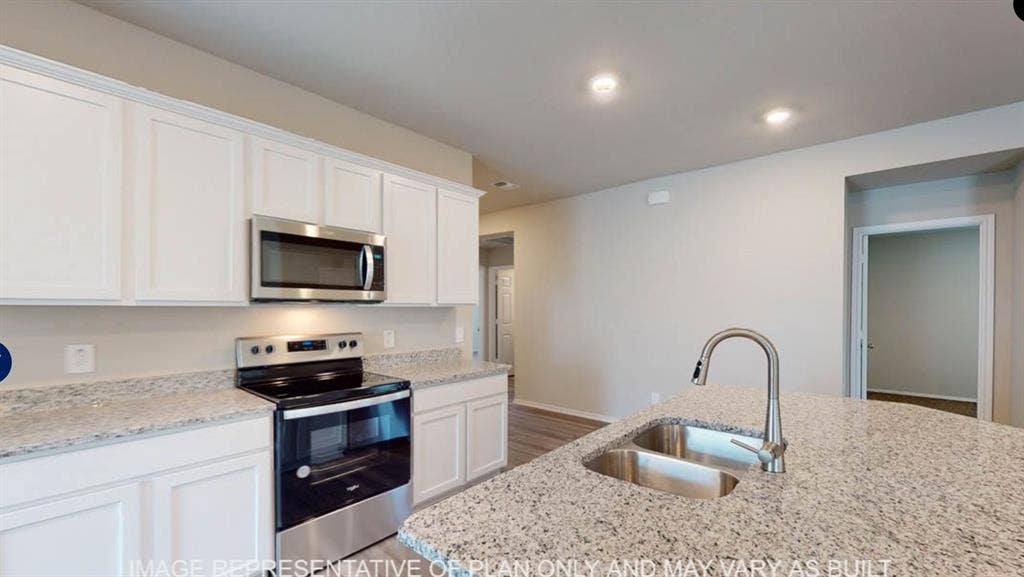 10217 Neptune Court, Waco, TX 76708 Kitchen featuring white cabinetry, stainless steel appliances, a double basin sink, and granite countertops