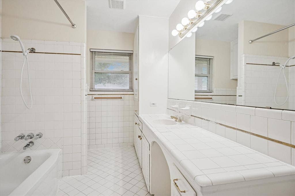 1725 Mapleton Drive, Dallas, TX 75228 Hall bath with tub and showerhead. Opens to bedroom three.