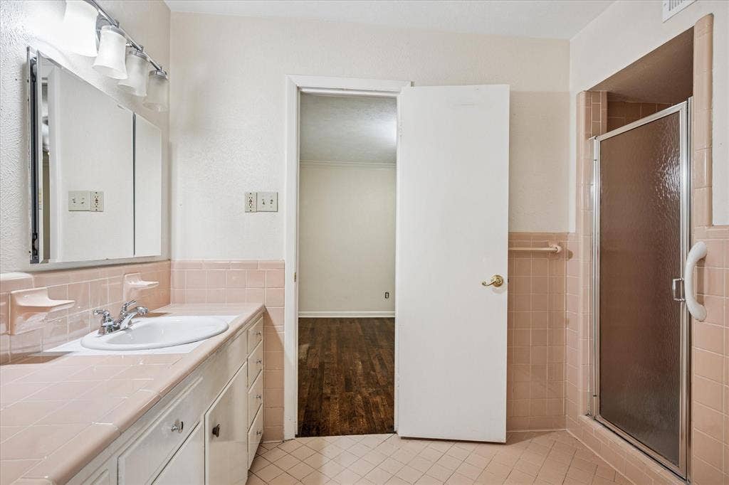 1725 Mapleton Drive, Dallas, TX 75228 Apricot-colored tile jack and jill bath with shower.
