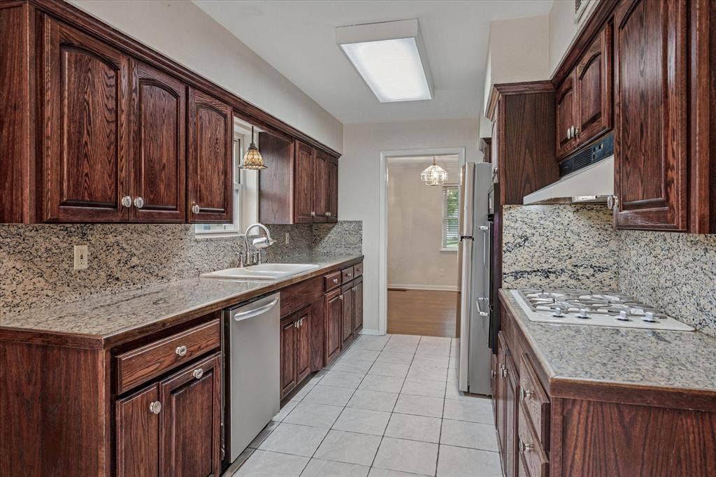 1725 Mapleton Drive, Dallas, TX 75228 All stainless, eat-in galley kitchen with broiler, gas cook top, solid wood cabs, and granite tile.