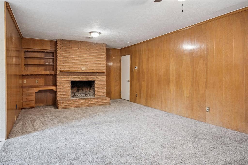 1725 Mapleton Drive, Dallas, TX 75228 Be cozy all winter with two fireplaces! Here's the second WBFP with gas starter. Natural wood-paneled den with built-in desk and shelves opens to covered patio.