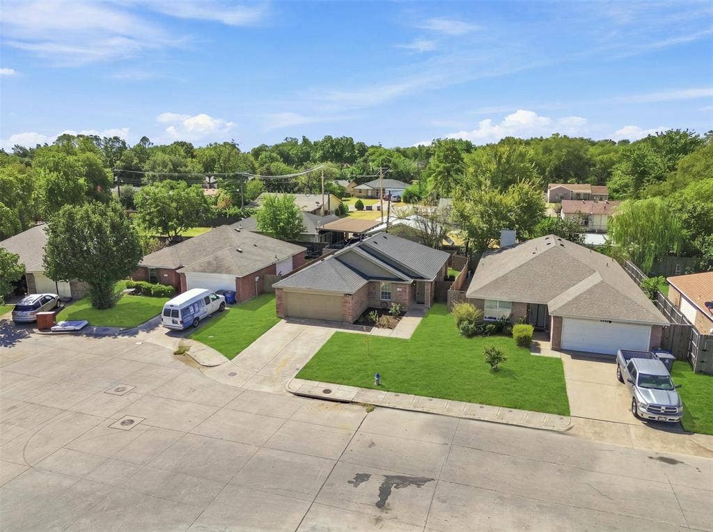 Single-story brick exterior, attached garage, concrete driveway, and a front lawn