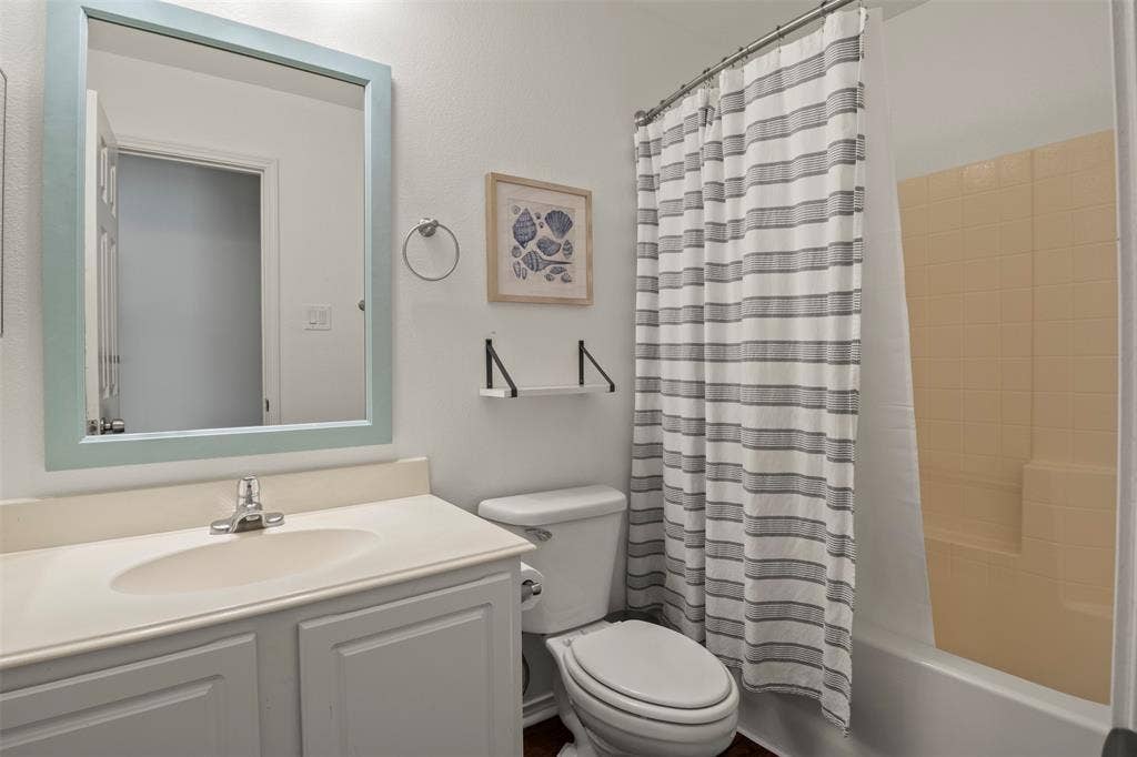 Bathroom vanity with an integrated sink and base cabinetry, complemented by a framed mirror
