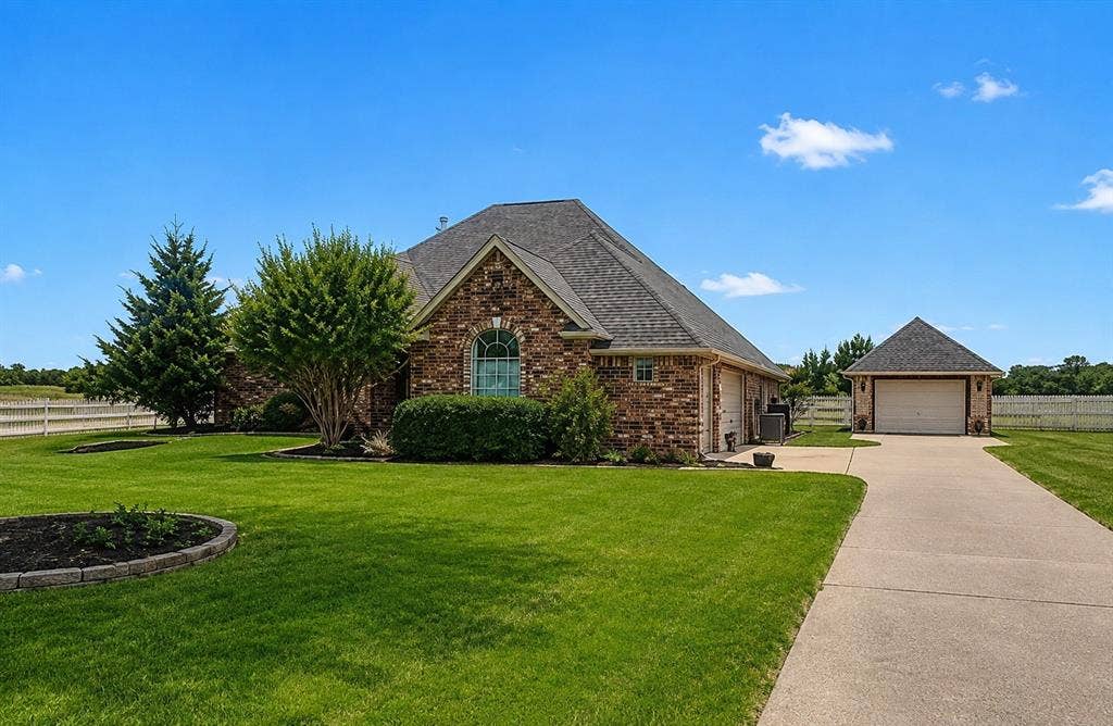 1908 Meadow Springs Drive, Haslet, TX 76052 Brick exterior with an arched window, a gabled roof, and an attached two-car garage