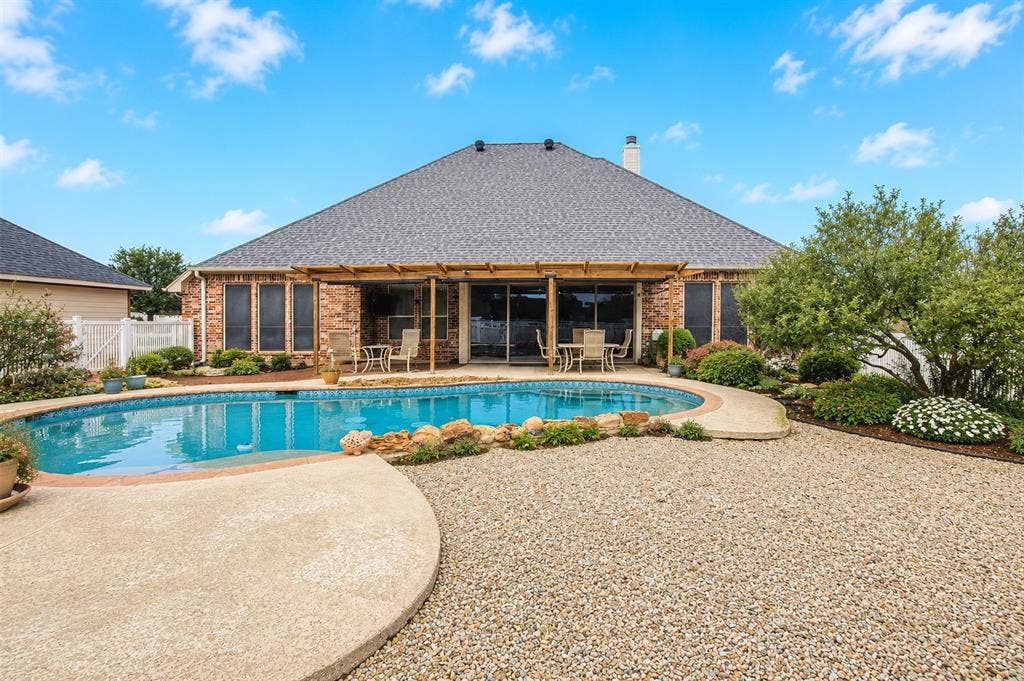 1908 Meadow Springs Drive, Haslet, TX 76052 Brick exterior with a shingle roof and a covered patio area