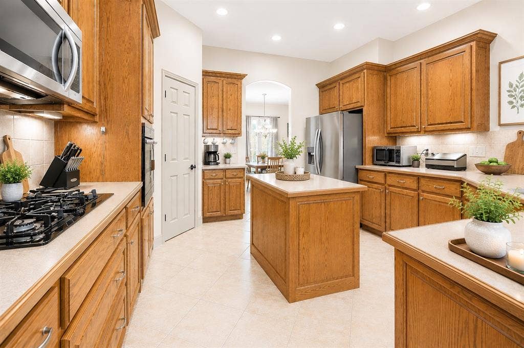 1908 Meadow Springs Drive, Haslet, TX 76052 Kitchen featuring wood cabinetry, stainless steel appliances, a central island, recessed lighting, and tile flooring