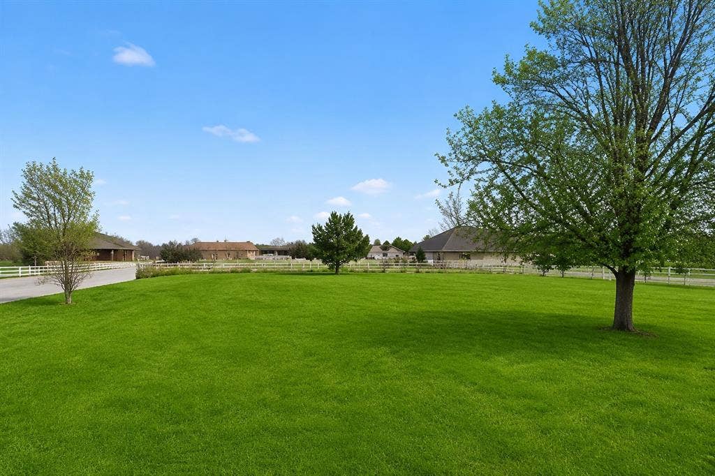 1908 Meadow Springs Drive, Haslet, TX 76052 Expansive green lawn with mature trees and a white fence