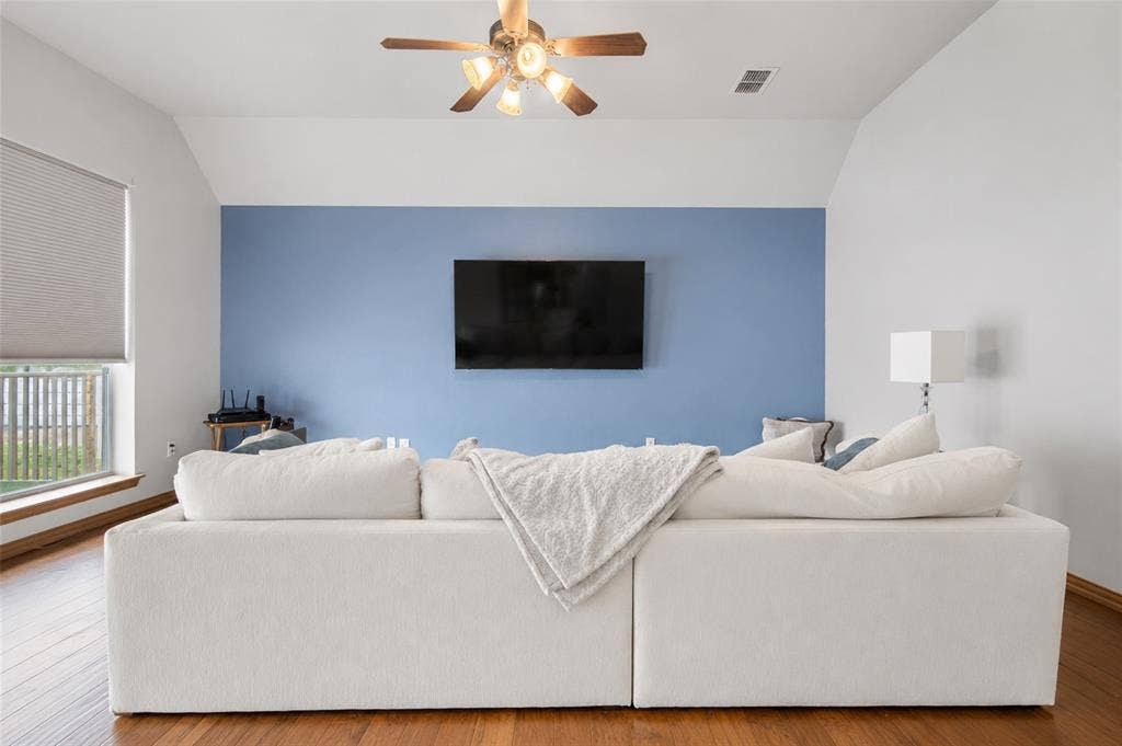 1908 Meadow Springs Drive, Haslet, TX 76052 Wood-finish flooring, vaulted ceiling, ceiling fan with integrated lighting, built-in window and window treatments, and mounted television