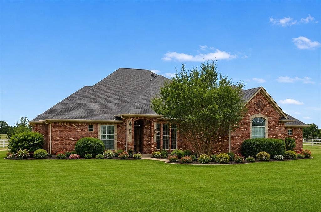 1908 Meadow Springs Drive, Haslet, TX 76052 Brick exterior with architectural shingles, detailed landscaping, arched entry, and arched window