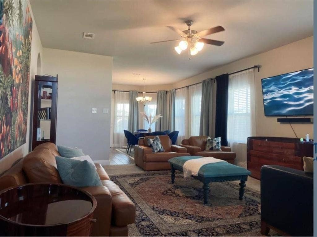 632 Redwood Drive, Greenville, TX 75402 Living area featuring a ceiling fan with integrated lighting, multiple windows with blinds, and an arched entryway