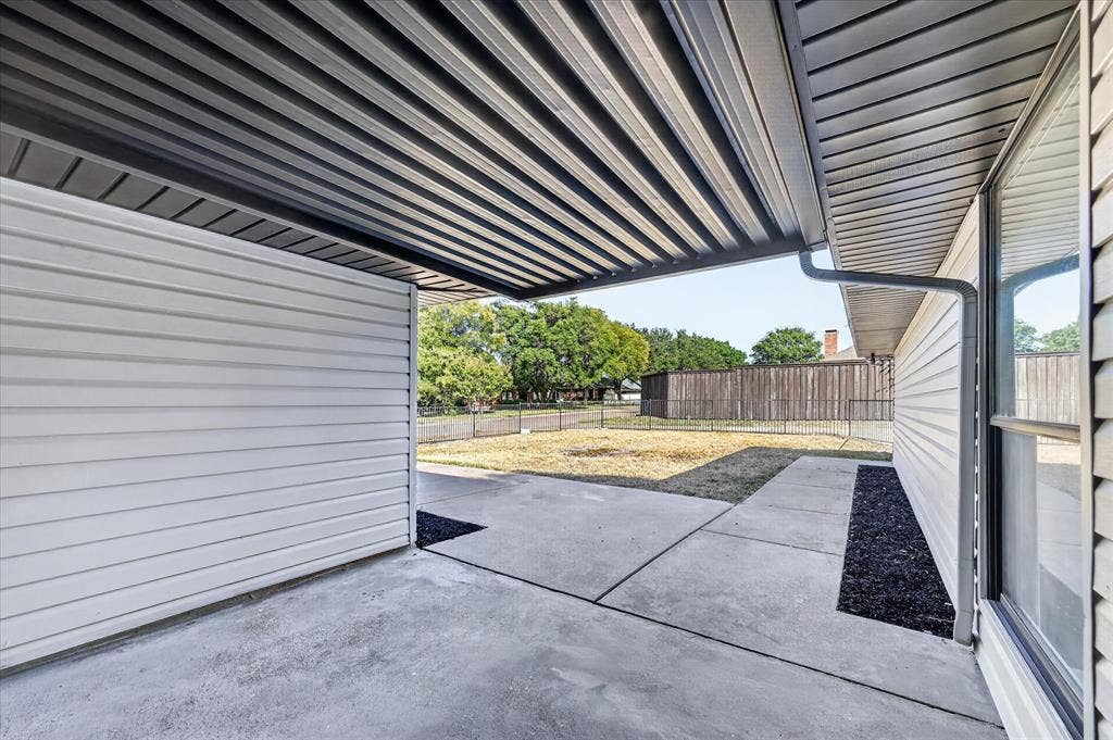 1528 Estrella Drive, Plano, TX 75074 Covered patio featuring a corrugated metal roof, concrete slab, and wood-finish siding