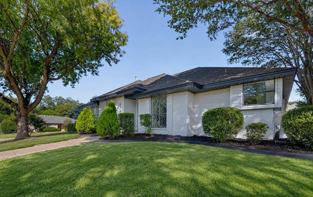 1528 Estrella Drive, Plano, TX 75074 White brick exterior with a dark roof and manicured landscaping