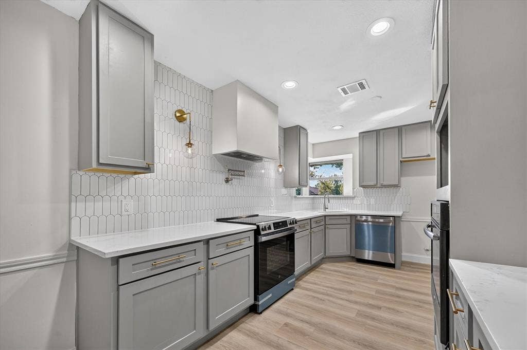 1528 Estrella Drive, Plano, TX 75074 Kitchen featuring taupe cabinetry, white countertops, wood-finish flooring, a stainless steel range, and a white picket tile backsplash